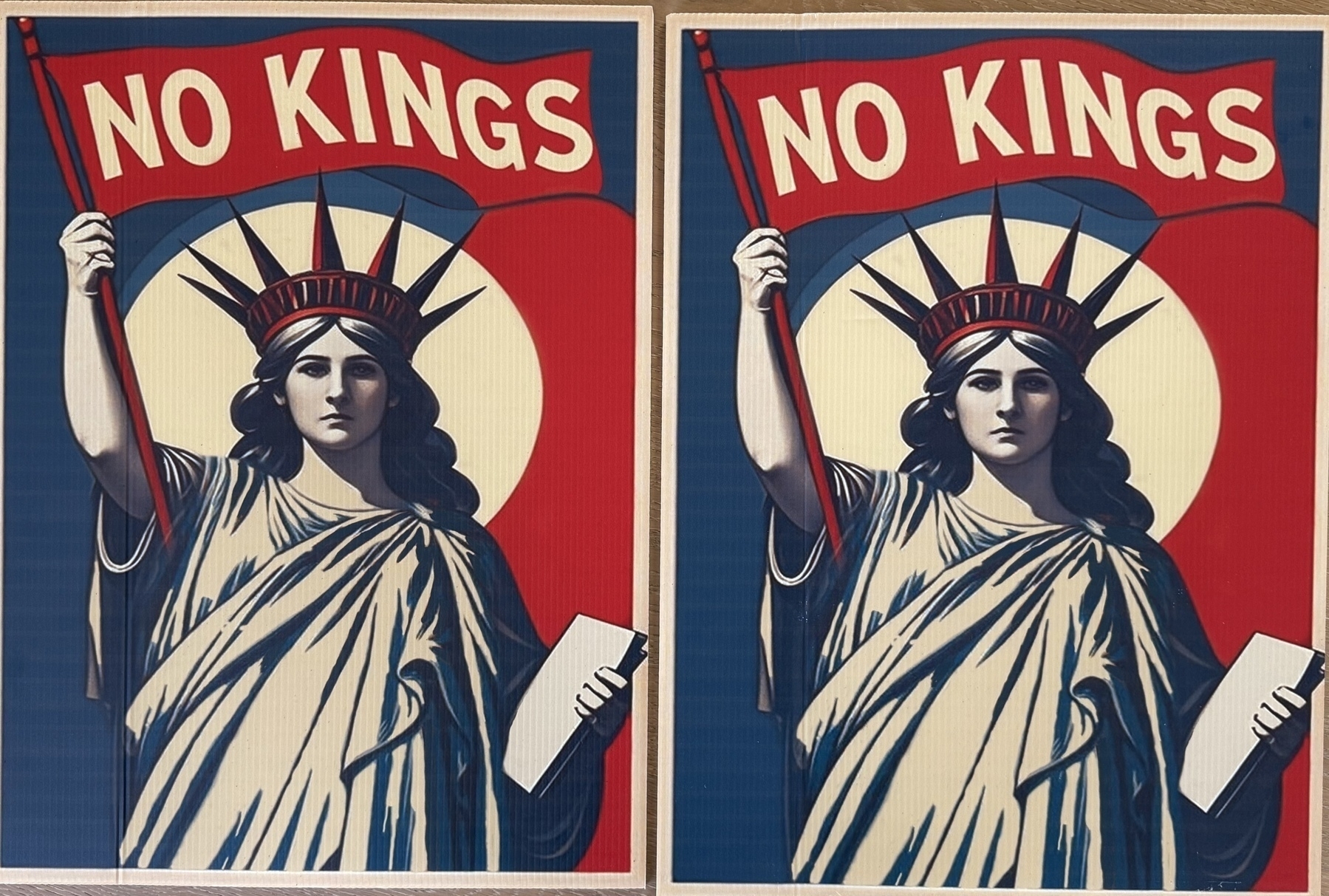 A depiction of the Statue of Liberty holding a "NO KINGS" banner.